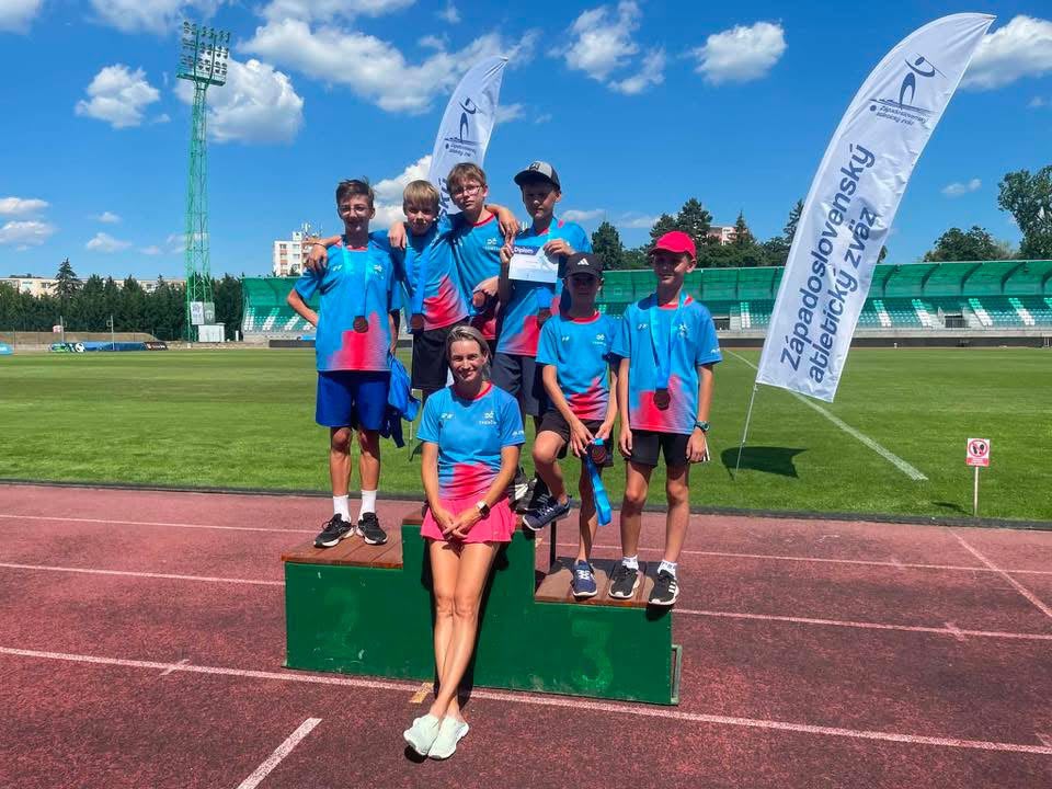 Mladší atléti s medailami a diplomom na stupňoch víťazov po pretekoch